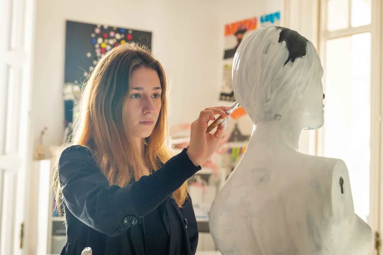 Student painting a mannequin