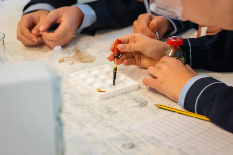 Hands of students doing experiments