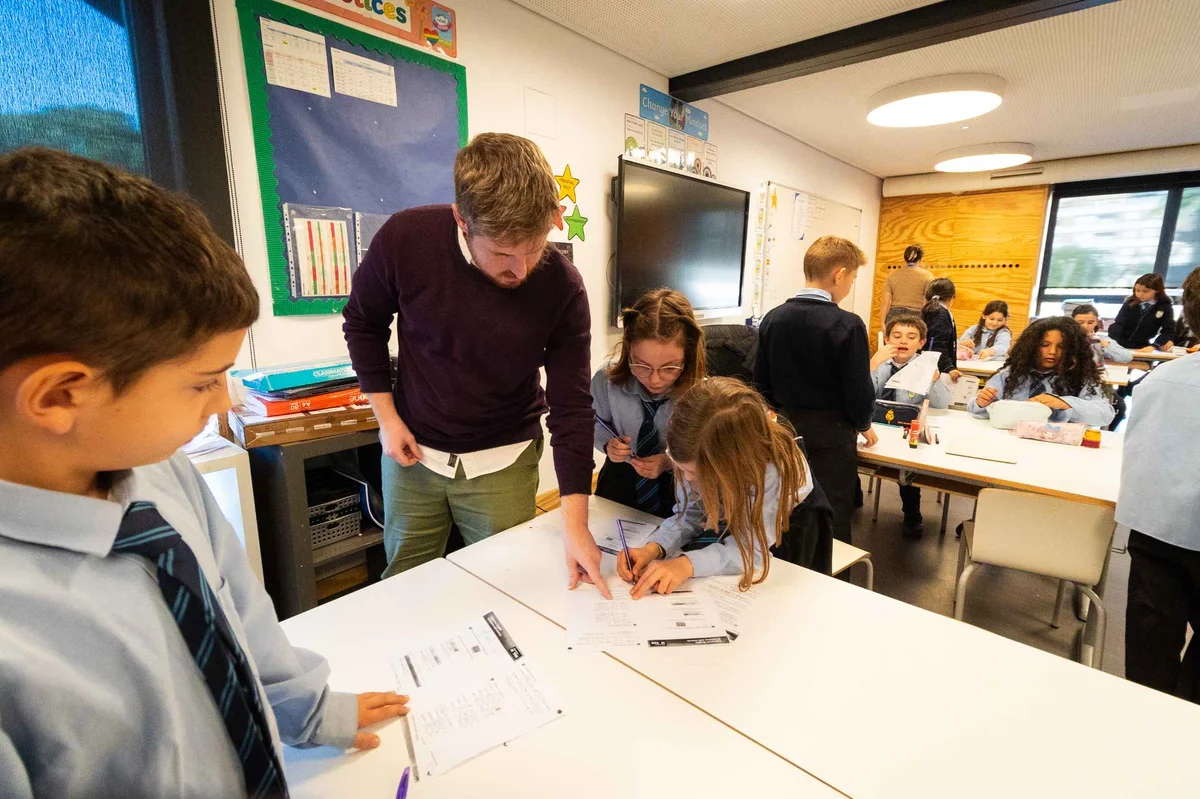 Teacher points to a paper on the desk to a student