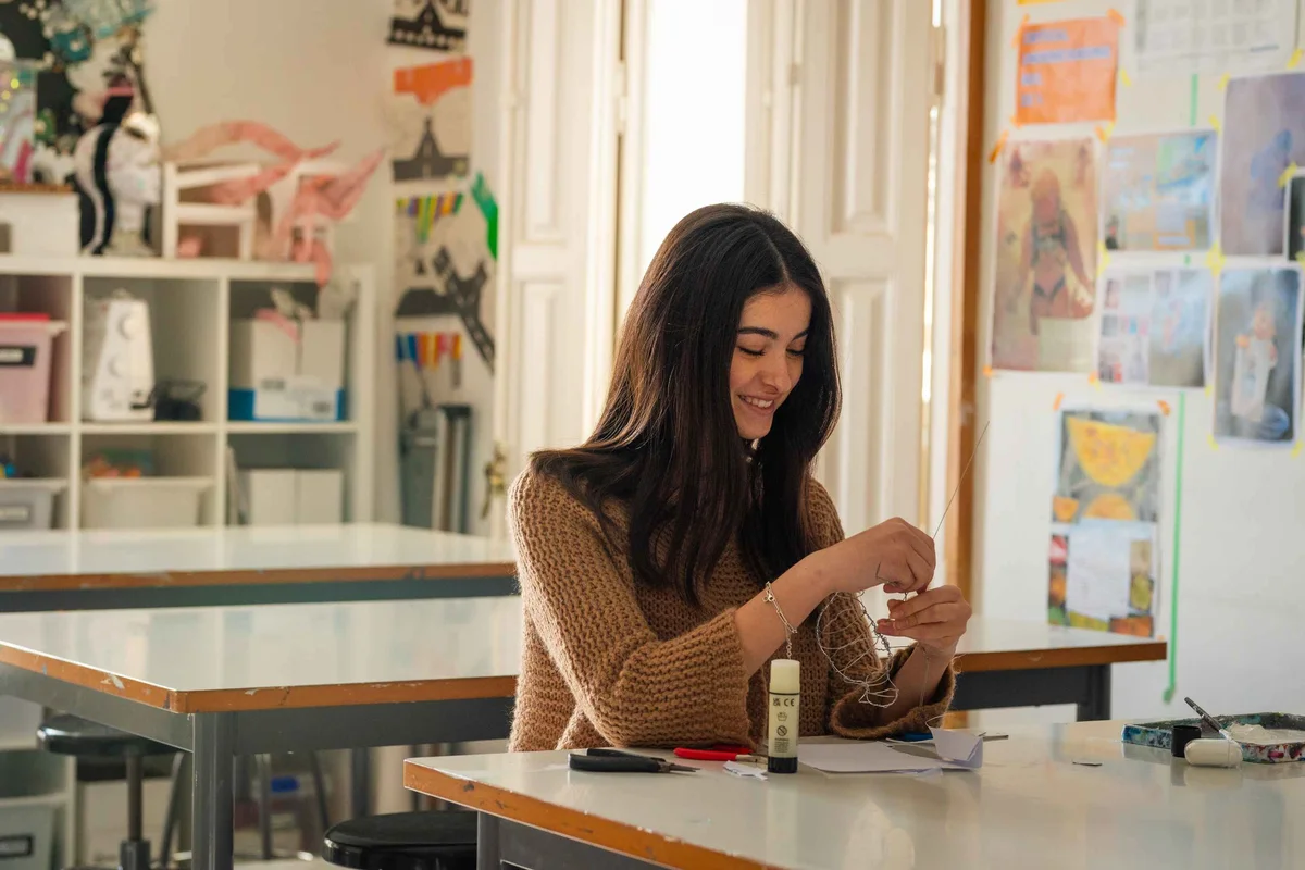 Student smiling while doing a job with the glue