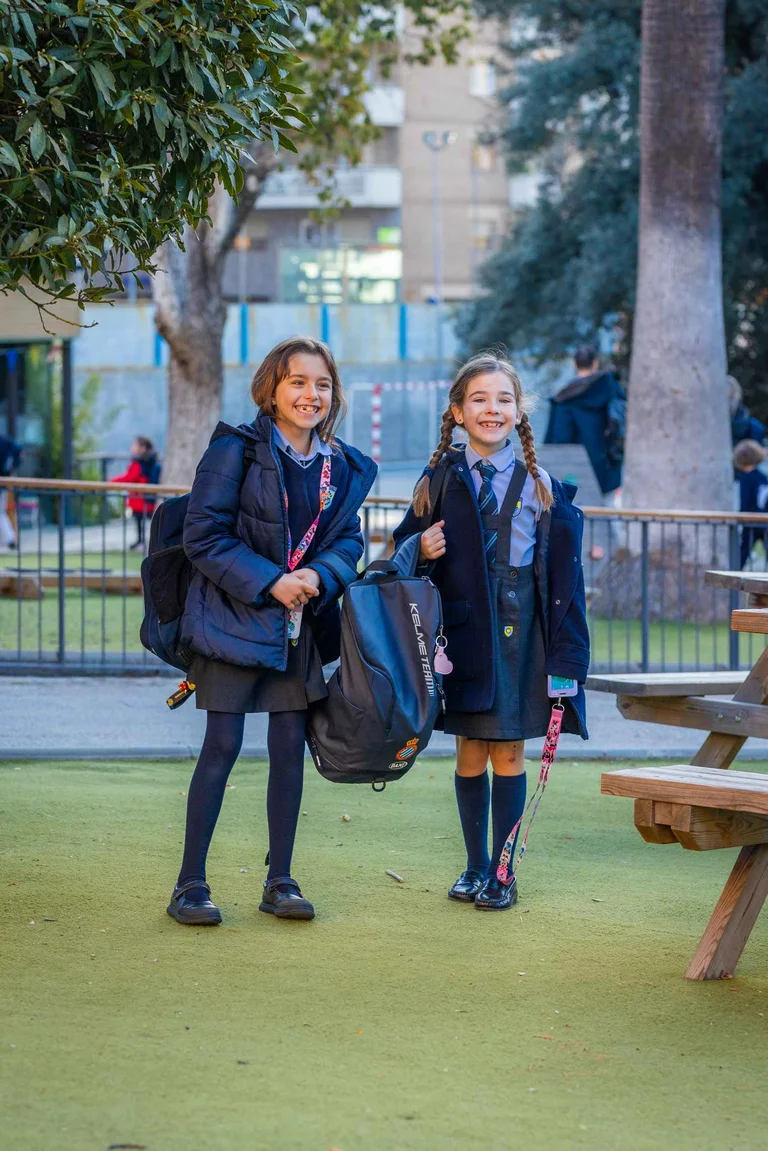 Two students in the schoolyard with backpack