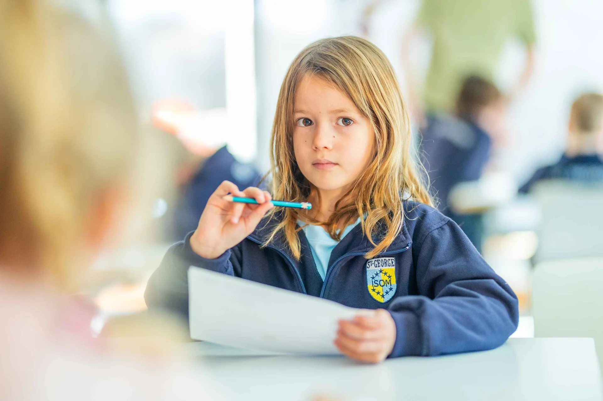 Student in uniform with pen and a paper